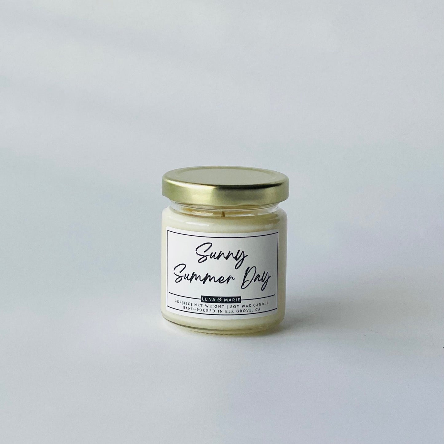 Candle jar labeled 'Sunny Summer Day' on a light gray background
